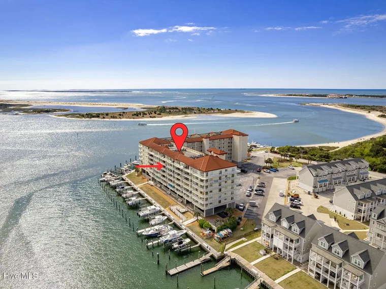 Aerial view of a waterfront condominium building with red tile roofs and boat slips on Radio Island, 100 Olde Towne Yacht Club Drive, Beaufort, North Carolina